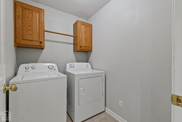 214 Holmes Rd, Jonesboro, AR 72405 - laundry room with cabinet space, washer and clothes dryer, and light tile patterned floors