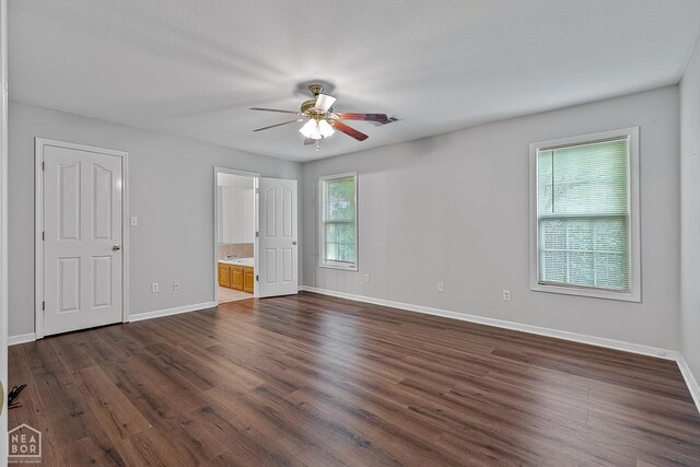 214 Holmes Rd, Jonesboro, AR 72405 - unfurnished bedroom with dark wood-type flooring, ensuite bathroom, and a ceiling fan