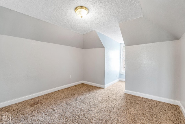 605 SE 2nd St SE, Hoxie, AR 72433 - bonus room featuring a textured ceiling, baseboards, lofted ceiling, and carpet