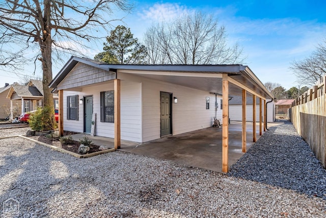 202 S 14th Ave, Paragould, AR 72450 - view of side of home featuring an attached carport, an outbuilding, and gravel driveway