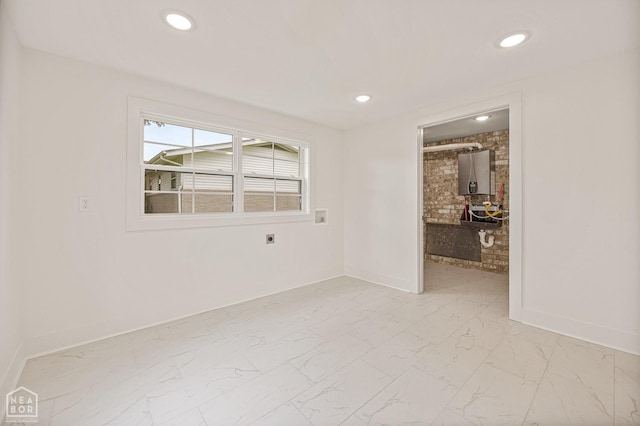 empty room with recessed lighting, water heater, marble finish floor, and baseboards
