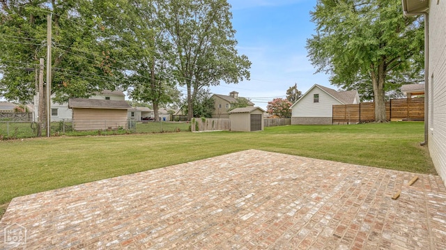 view of yard with a patio, a fenced backyard, an outdoor structure, and a storage unit