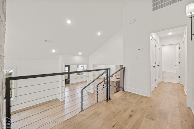 corridor with baseboards, an upstairs landing, hardwood / wood-style floors, and recessed lighting
