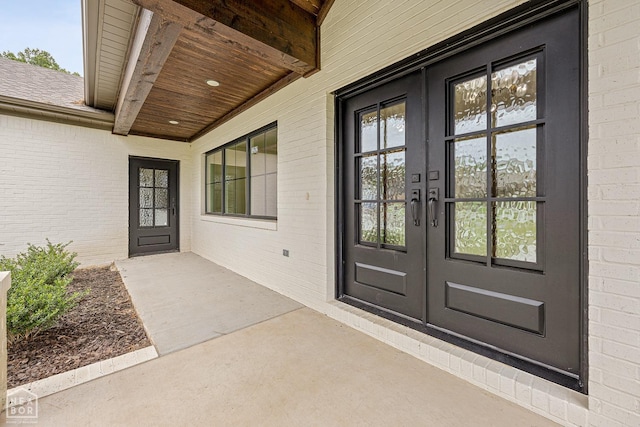 entrance to property featuring brick siding and french doors