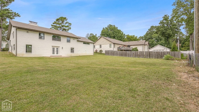 view of yard featuring french doors and fence