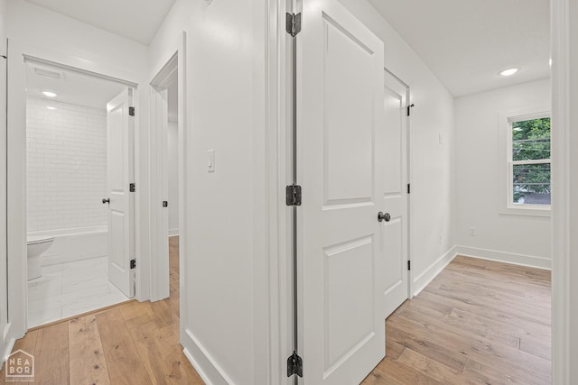 hall with recessed lighting, light wood-type flooring, and baseboards