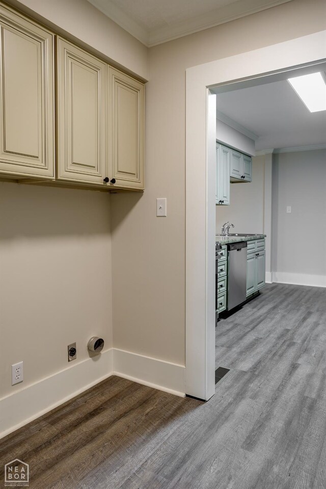 laundry room featuring baseboards, ornamental molding, hookup for an electric dryer, light wood finished floors, and cabinet space