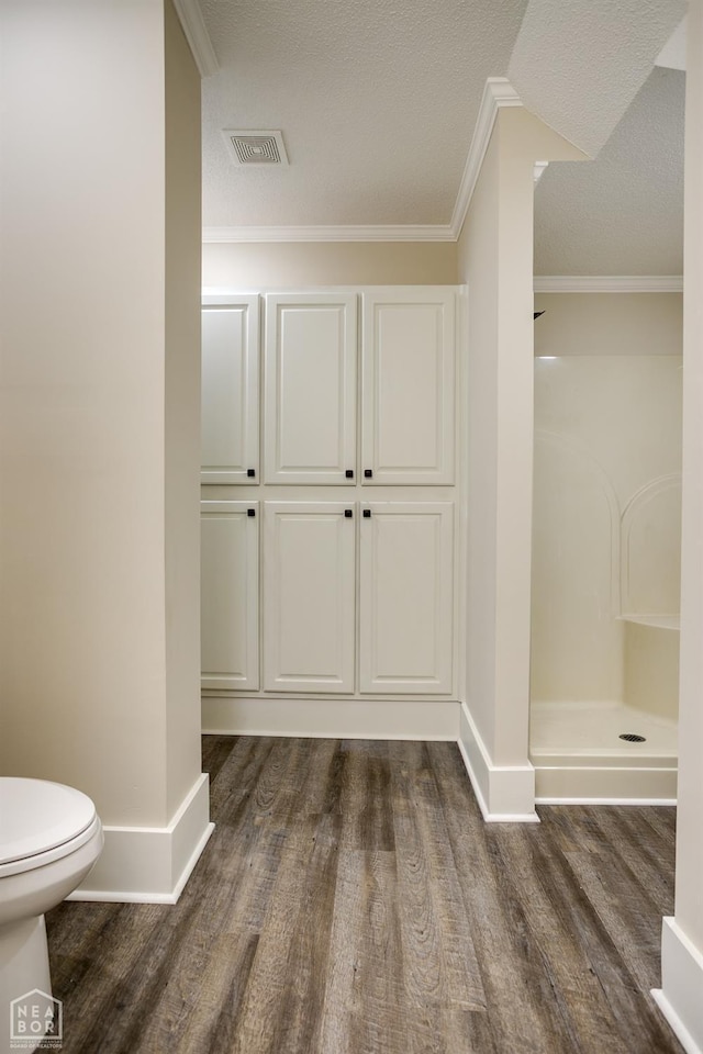 full bath with baseboards, toilet, visible vents, a shower, and wood finished floors
