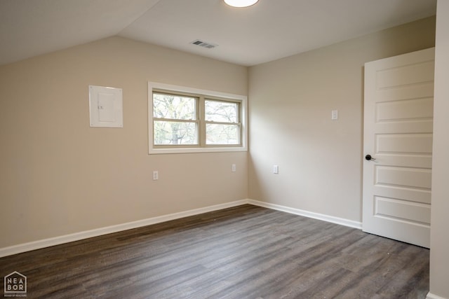 unfurnished room with visible vents, dark wood-style flooring, baseboards, and lofted ceiling