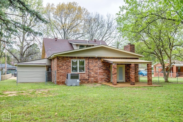 exterior space featuring a front yard, fence, brick siding, and a chimney