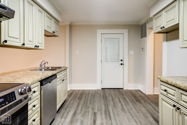 kitchen featuring crown molding, appliances with stainless steel finishes, light wood finished floors, range hood, and a sink