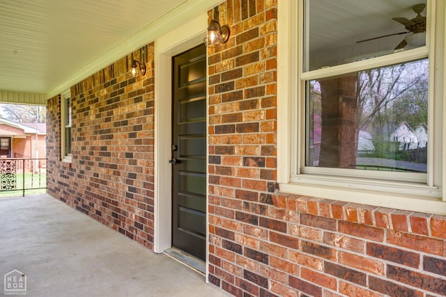 property entrance featuring a porch and brick siding