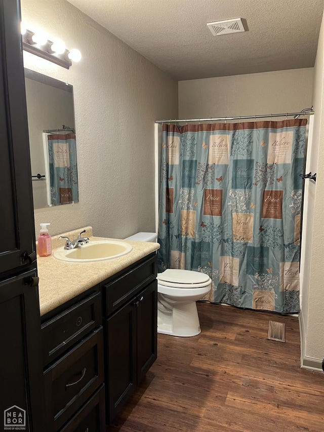 4903 Wise St, Paragould, AR 72450 - full bathroom featuring wood finished floors, vanity, a textured wall, toilet, and a textured ceiling