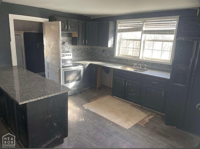 kitchen featuring black refrigerator with ice dispenser, a sink, stainless steel electric stove, a peninsula, and decorative backsplash