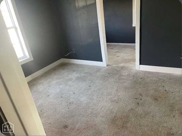 spare room with baseboards and carpet floors