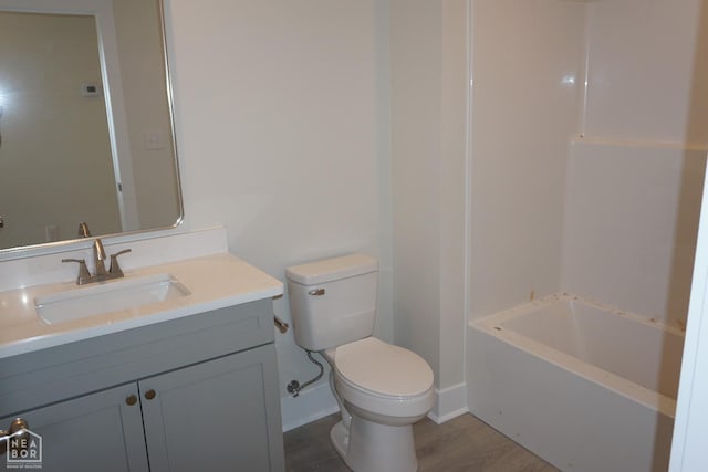 full bath with toilet, wood finished floors, and vanity