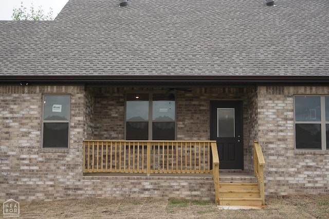 property entrance with brick siding and roof with shingles