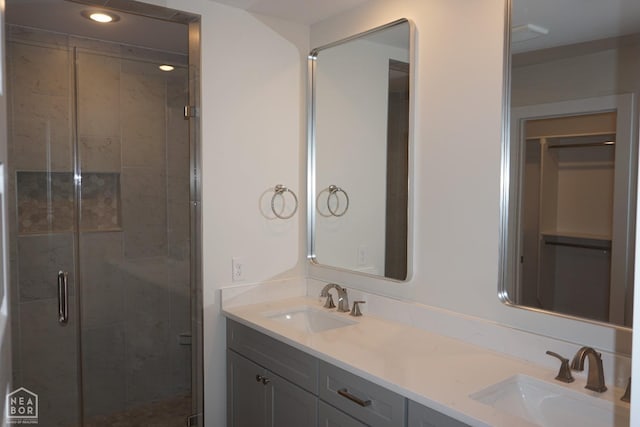full bathroom featuring double vanity, a sink, recessed lighting, and a shower stall
