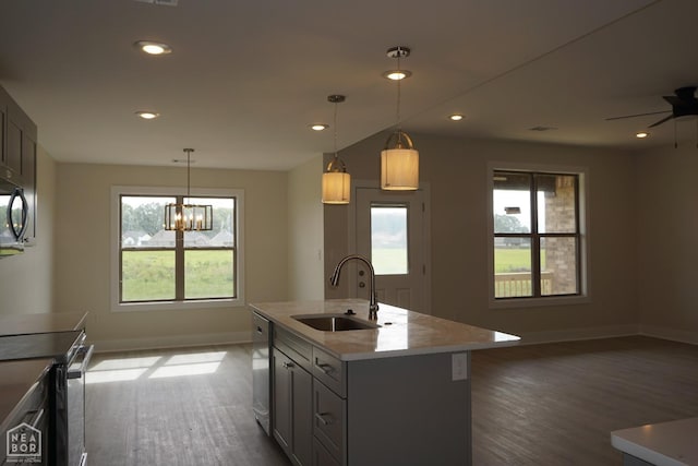 kitchen featuring dark wood-style flooring, a sink, baseboards, light countertops, and stainless steel appliances