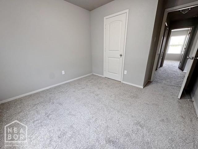 carpeted spare room with baseboards