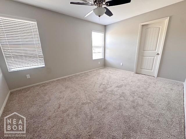 empty room featuring ceiling fan, carpet floors, and baseboards