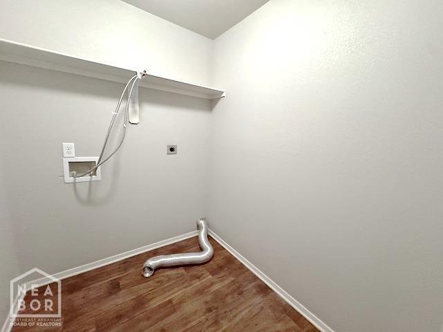 clothes washing area featuring wood finished floors, washer hookup, and baseboards