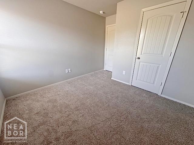 unfurnished bedroom with carpet floors and baseboards