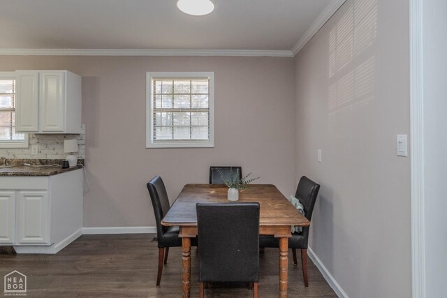 dining area featuring crown molding, dark wood-style flooring, and baseboards