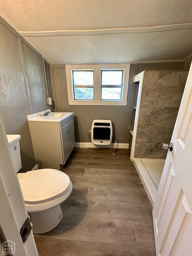 513 Lewis Ave, Trumann, AR 72472 - bathroom with a textured ceiling, toilet, wood finished floors, walk in shower, and heating unit