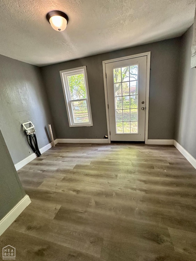 513 Lewis Ave, Trumann, AR 72472 - doorway featuring baseboards, wood finished floors, and a textured ceiling