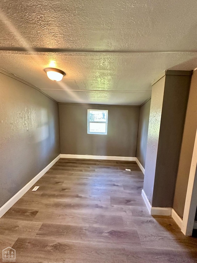 513 Lewis Ave, Trumann, AR 72472 - empty room with a textured wall, baseboards, wood finished floors, and a textured ceiling