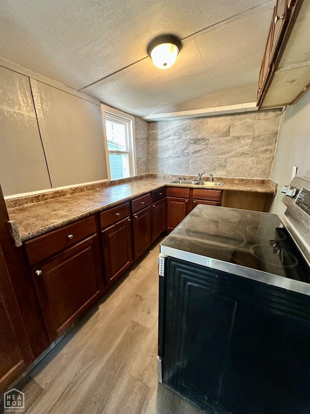513 Lewis Ave, Trumann, AR 72472 - kitchen featuring a sink, light countertops, light wood-style floors, a textured ceiling, and stainless steel electric range