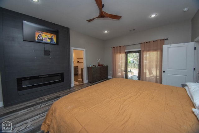 bedroom featuring visible vents, a fireplace, recessed lighting, connected bathroom, and wood finished floors