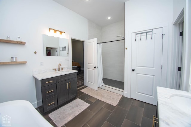 bathroom with a freestanding bath, tiled shower, vanity, and recessed lighting
