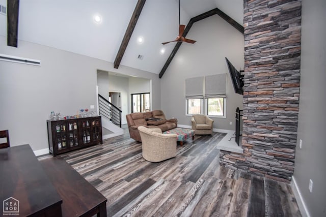 living area featuring baseboards, ceiling fan, beamed ceiling, wood finished floors, and high vaulted ceiling