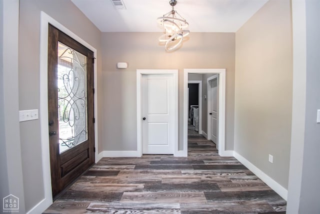 entrance foyer with a notable chandelier, baseboards, visible vents, and dark wood finished floors