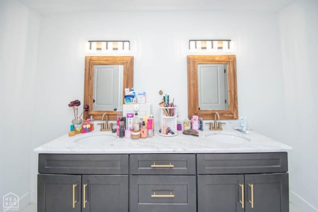 full bathroom with a sink, baseboards, and double vanity