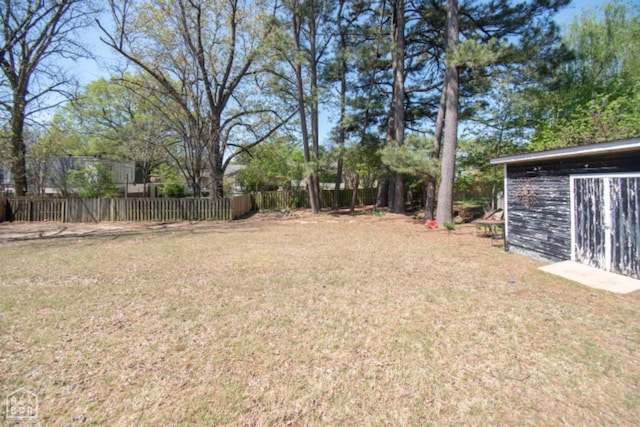 view of yard with fence and an outbuilding