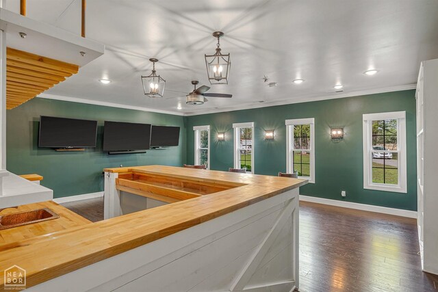 interior space featuring baseboards, ornamental molding, and dark wood finished floors