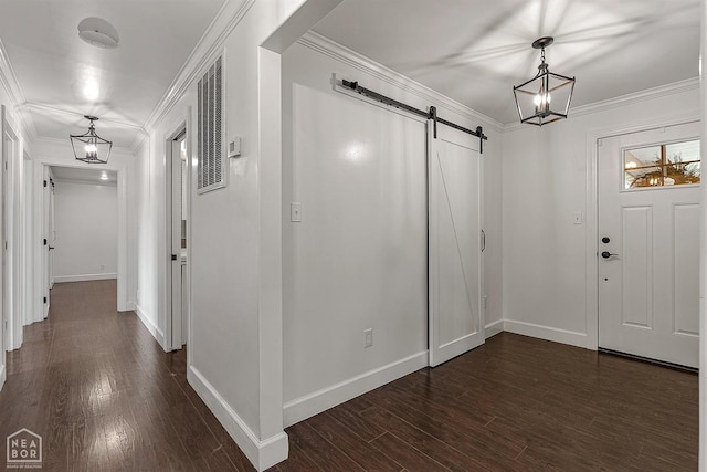 entrance foyer with a barn door, baseboards, crown molding, and dark wood finished floors