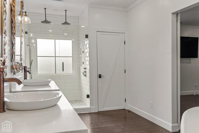 bathroom with baseboards, crown molding, a sink, and a stall shower
