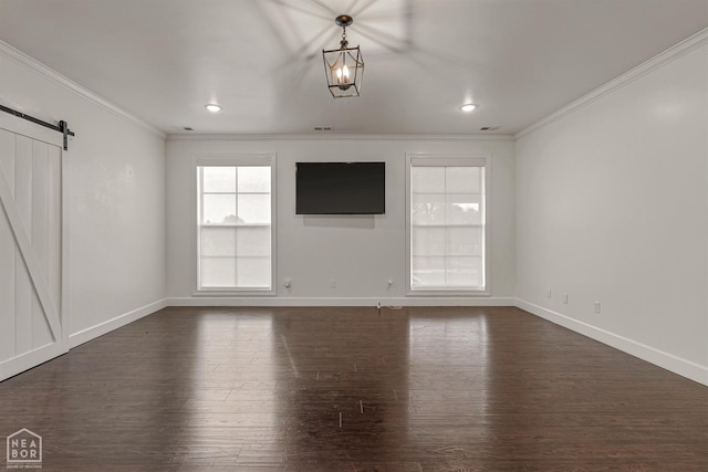 unfurnished living room featuring a barn door, dark wood-type flooring, baseboards, and ornamental molding