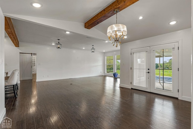 unfurnished living room with recessed lighting, a barn door, dark wood-style floors, and baseboards