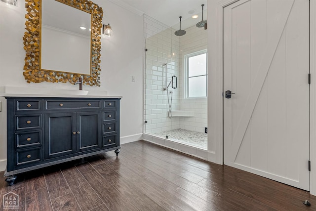 bathroom featuring vanity, baseboards, a stall shower, and wood finished floors