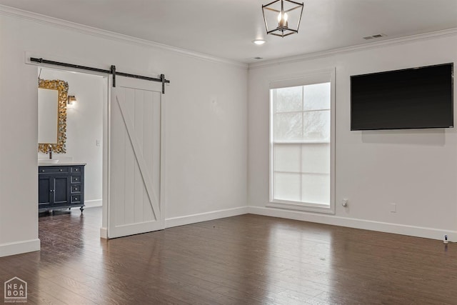unfurnished living room featuring a wealth of natural light, dark wood-type flooring, a barn door, and crown molding