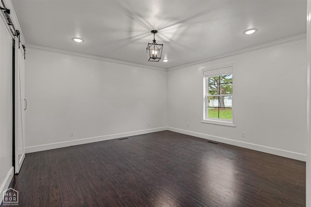 unfurnished room featuring dark wood-style floors, baseboards, ornamental molding, and a barn door