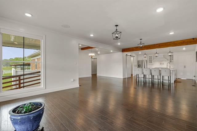 unfurnished living room featuring baseboards, recessed lighting, a barn door, and dark wood-style floors
