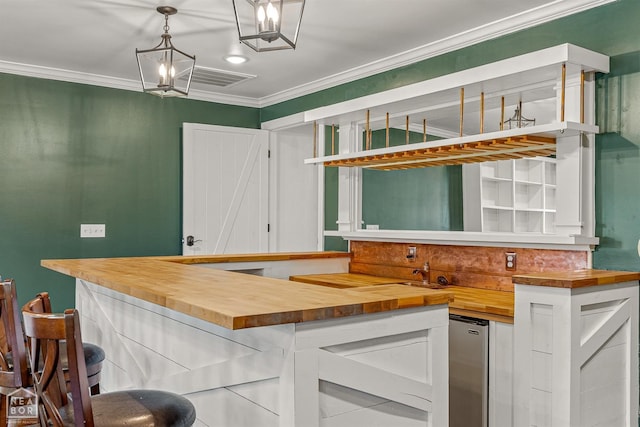 kitchen featuring visible vents, white cabinets, ornamental molding, wood counters, and pendant lighting