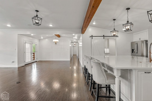 kitchen with baseboards, light countertops, white cabinets, stainless steel refrigerator with ice dispenser, and a barn door