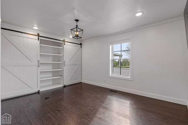 interior space with crown molding, baseboards, visible vents, and a barn door